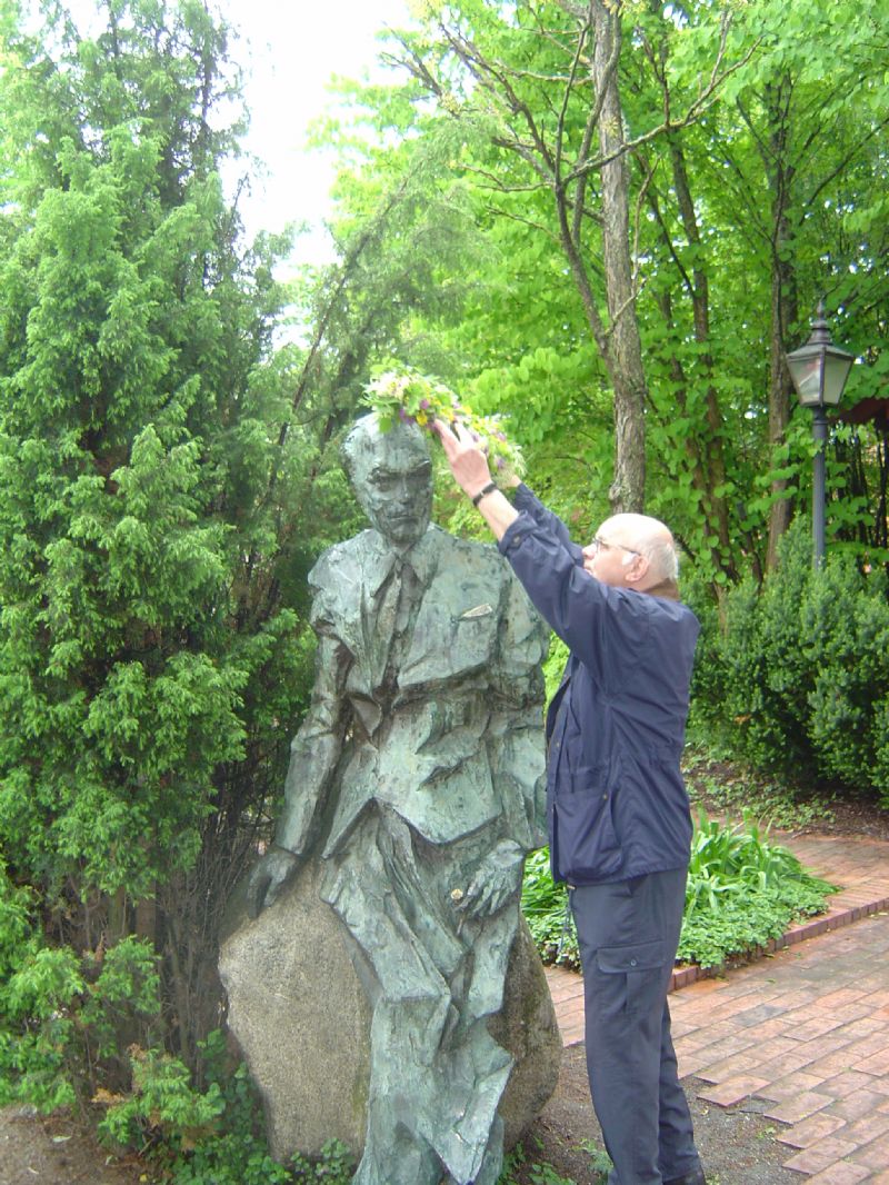 Hasse Eson avslutar arrangemanget Första frukost i Fridegårdsparken 2007 genom att sätta en blomsterkrans på Jans huvud. 